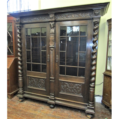 2162 - A substantial German oak side cupboard of full height, the front elevation enclosed by two panelled ... 