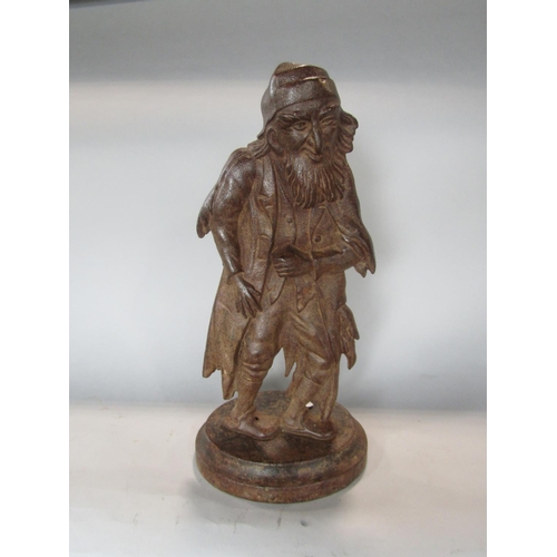 540 - A figural cast iron fire iron holder in the form of a fagan looking character, 38 cm high