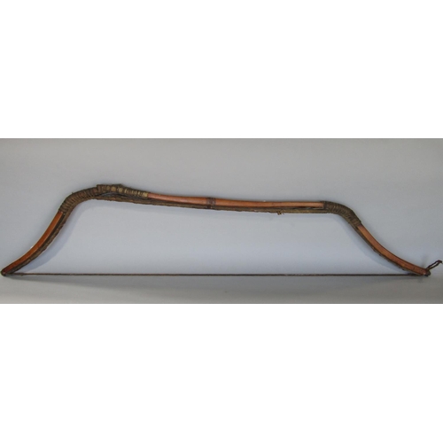 622 - An antique inuit bow in cedar wood, with additonal hide and plaited cord detail, 123 cm in length