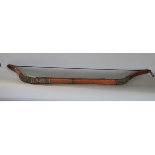 622 - An antique inuit bow in cedar wood, with additonal hide and plaited cord detail, 123 cm in length