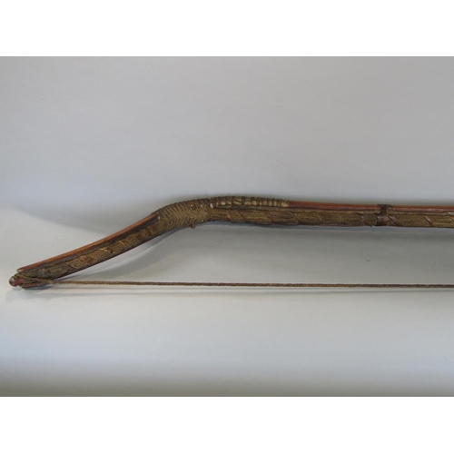 622 - An antique inuit bow in cedar wood, with additonal hide and plaited cord detail, 123 cm in length