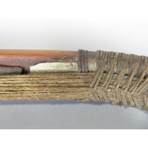 622 - An antique inuit bow in cedar wood, with additonal hide and plaited cord detail, 123 cm in length