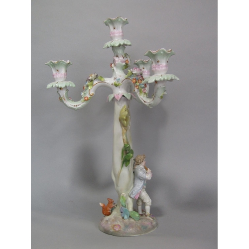 100 - A late 19th century German porcelain three branch candelabra with a piper standing beneath a tree, t... 