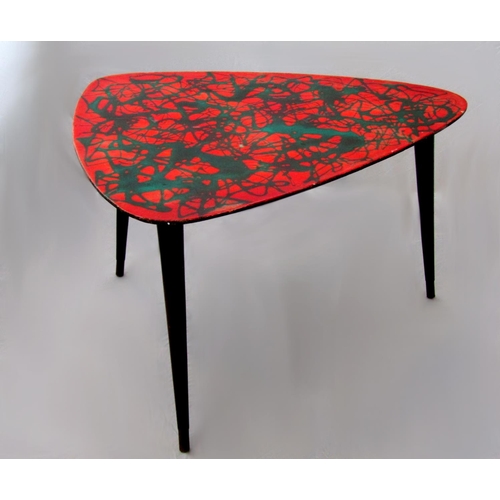 210 - 1950s Italian coffee table the red lacquered top with abstract design upon three ebonised tapered le... 