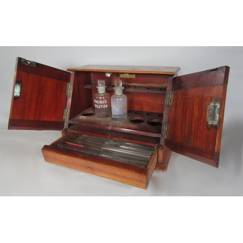 573 - Early 20th century mahogany medical cabinet, the twin doors enclosing two apothecary bottles and a f... 