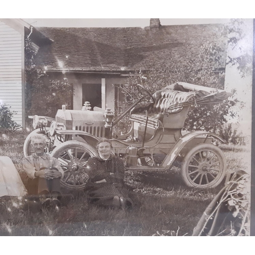 306 - An early 20th century sepia coloured photograph of an American family seated outside their house wit... 