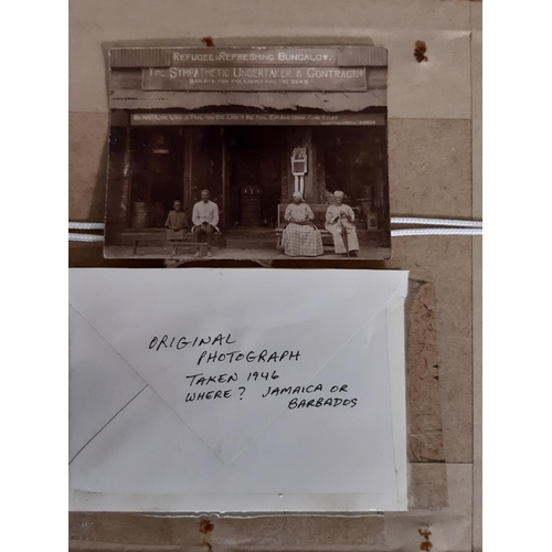 306 - An early 20th century sepia coloured photograph of an American family seated outside their house wit... 