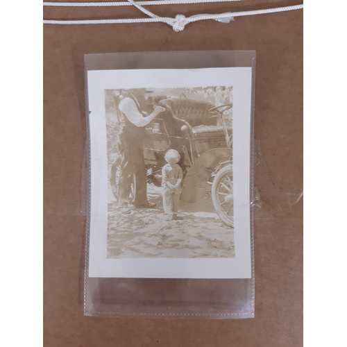 306 - An early 20th century sepia coloured photograph of an American family seated outside their house wit... 