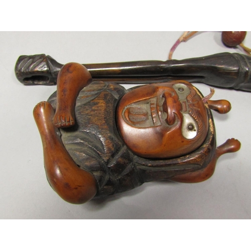 1513 - A Betel nut holder in the form of a seated character, a further carved character arms outstretched