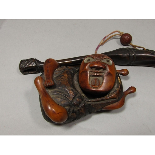 1513 - A Betel nut holder in the form of a seated character, a further carved character arms outstretched