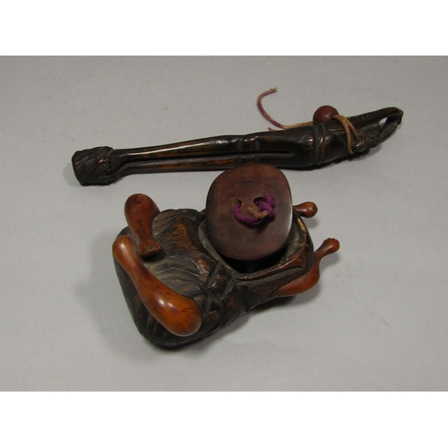 1513 - A Betel nut holder in the form of a seated character, a further carved character arms outstretched