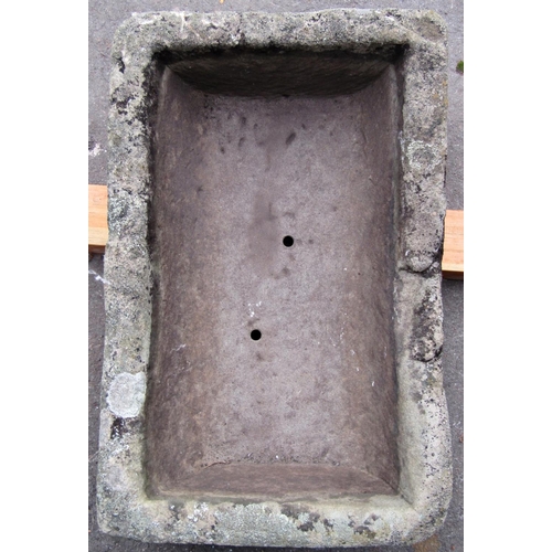 2071 - A shallow weathered natural stone trough of rectangular form with two drilled drainage holes, 59cm l... 