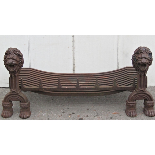 2074 - A large/wide heavy cast iron fire basket and loose dogs, with lions mask finials and paw feet, the g... 