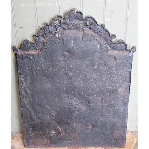 2094 - A cast iron fireback of stepped arched form, with raised relief lions mask, fruiting vine and horsem... 