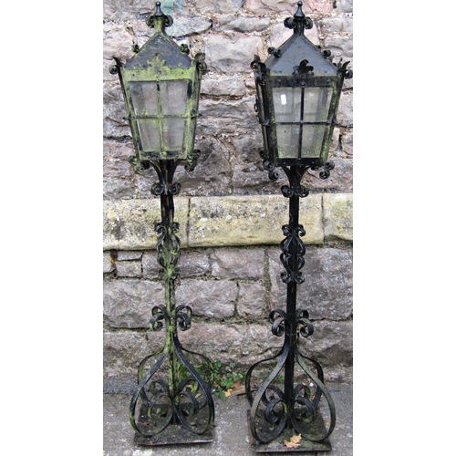 2109 - A pair of iron work lanterns with tapered glazed panels, scrolled detail and supports with square fi... 