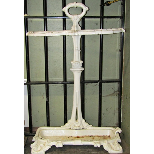 2110 - A cast iron two divisional umbrella/stick stand with shaped outline, scrolled foliate detail and rem... 