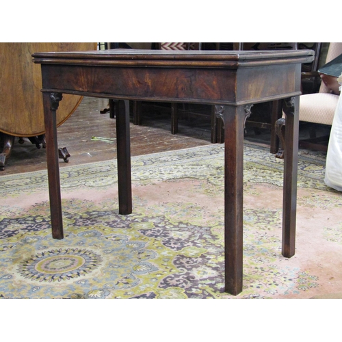 2730 - A Georgian mahogany serpentine fold over card table on chamfered supports with further carved detail... 