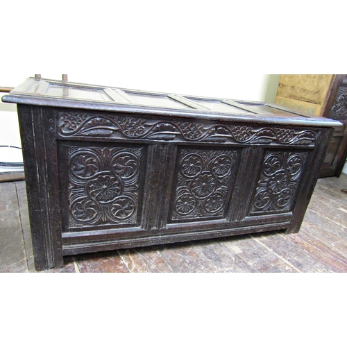 2756 - An 18th century oak coffer with panelled framework, the front elevation with carved floral detail se... 