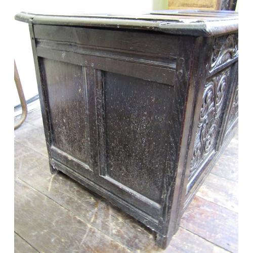 2756 - An 18th century oak coffer with panelled framework, the front elevation with carved floral detail se... 