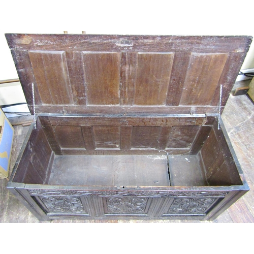 2756 - An 18th century oak coffer with panelled framework, the front elevation with carved floral detail se... 