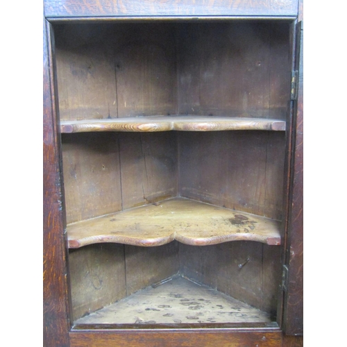 2766 - A small 18th century oak hanging  corner cupboard with panelled door and set beneath a dentil frieze... 