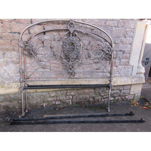 2136a - A 19th century 4ft 6 steel bedstead with arched tubular frame and decorative cast foliate detail com... 