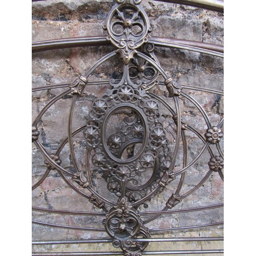 2136a - A 19th century 4ft 6 steel bedstead with arched tubular frame and decorative cast foliate detail com... 