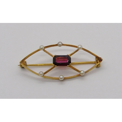 324 - Yellow metal marquise shaped brooch set with a garnet and seed pearls, 3g