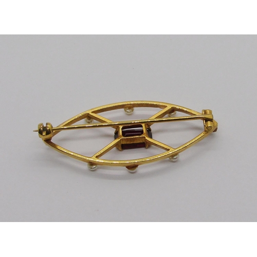 324 - Yellow metal marquise shaped brooch set with a garnet and seed pearls, 3g