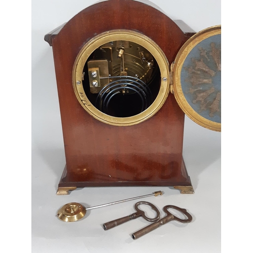 401 - An inlaid Edwardian mahogany mantel clock with convex enamelled dial, French eight day striking move... 