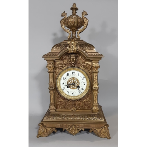 402 - A substantial Victorian mantel clock in a cast brass case detailing mask, scroll and repeating geome... 