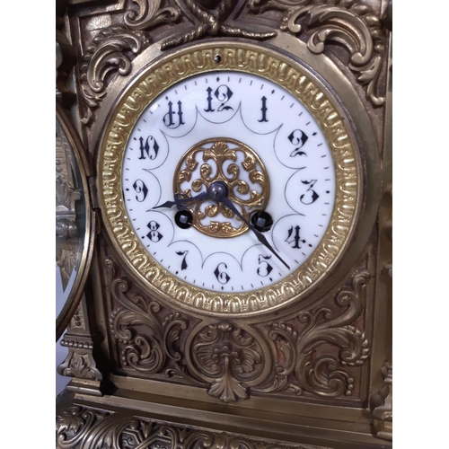 402 - A substantial Victorian mantel clock in a cast brass case detailing mask, scroll and repeating geome... 