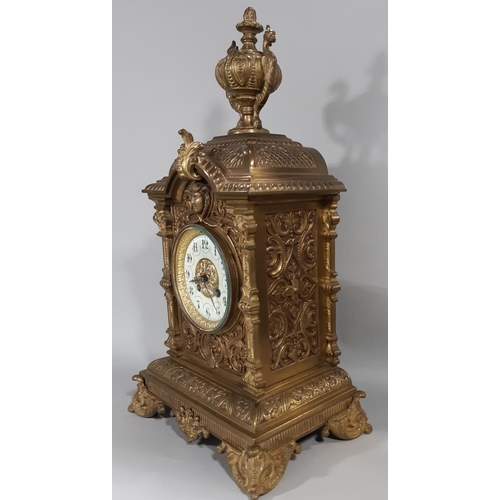 402 - A substantial Victorian mantel clock in a cast brass case detailing mask, scroll and repeating geome... 