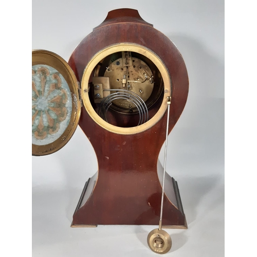 406 - An inlaid Edwardian mahogany mantel clock in a balloon shaped case with convex enamelled dial and ei... 