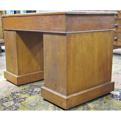 1533 - An oak pedestal desk of nine graduated drawers with brass plate handles and inset top, 110cm wide