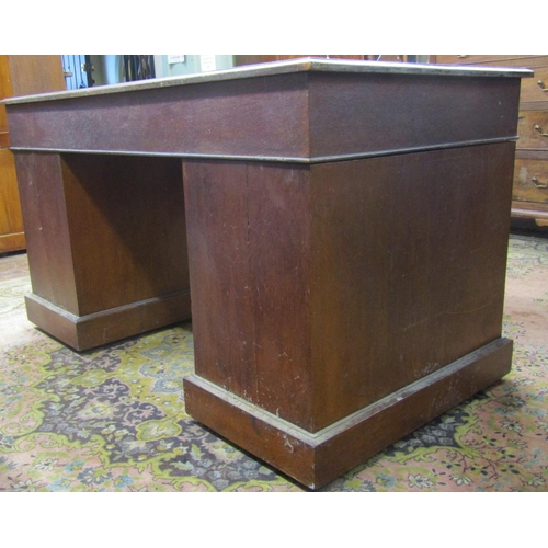 1534 - A late 20th century oak pedestal writing desk fitted with nine graduated drawers with brass plate ha... 