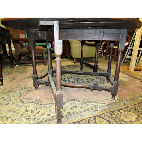 1535 - An 18th century oak gateleg dining table raised on turned supports and stretchers, 115cm long to sea... 