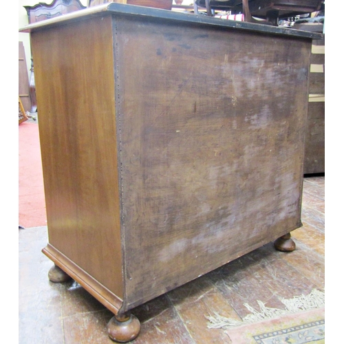 1543 - A walnut veneered chest of four long graduated drawers, the top with crossbanded detail raised on bu... 