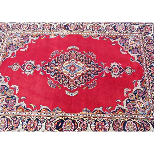 1476 - An Akashan rug with central floral pattern medallion on a red ground within foliate running borders,... 