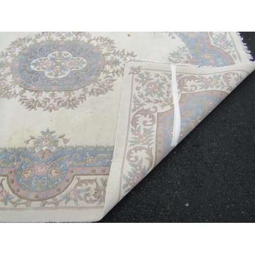 1489 - An Indian heavy cream ground washed wool carpet with floral decoration in pastel shades