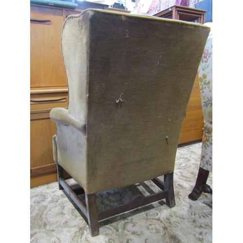 2332 - A Georgian style wing armchair, with shaped and rolled outline and upholstered finish, raised on squ... 