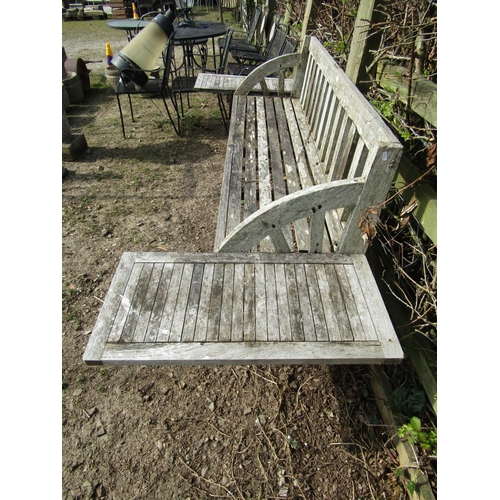 47 - An unusual, weathered teak garden bench with slatted seat, back and arched arms, with later table to... 