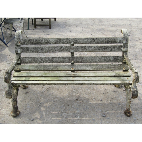 315 - A Victorian two seat garden bench with timber lathes raised on a pair of heavy gauge cast iron natur... 