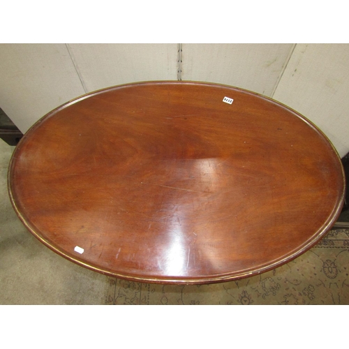 2049 - An unusual mahogany occasional table, the oval tray top with brass string inlay raised on a central ... 