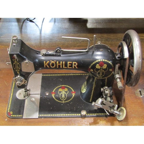 2081 - A Kohler treadle sewing machine with Art Nouveau transfer detail, the cast iron base with pierced de... 