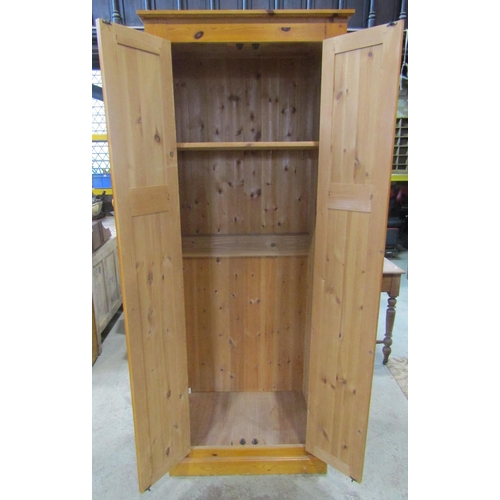 2100 - A modern pine side cupboard floorstanding and enclosed by a pair of full length twin fielded panelle... 