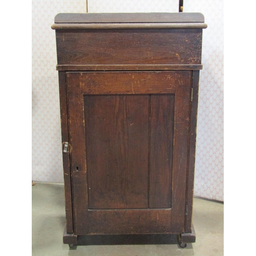 2146 - A vintage stained pine clerks/school desk with hinged slope and over a cupboard to reverse and sledg... 