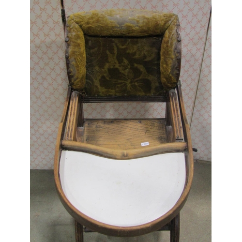 2151 - An Edwardian metamorphic child's high chair with shaped outline and raised on iron wheels