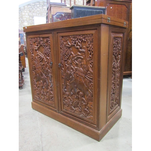 2157 - A Chinese hardwood cocktail bar with fold over top enclosed by two carved and panelled doors with fi... 