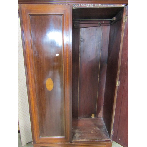 2180 - A small inlaid Edwardian mahogany wardrobe enclosed by a pair of three quarter length panelled doors... 